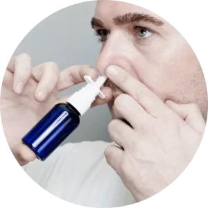 Male spraying anti-snoring nasal spray in his nose. 